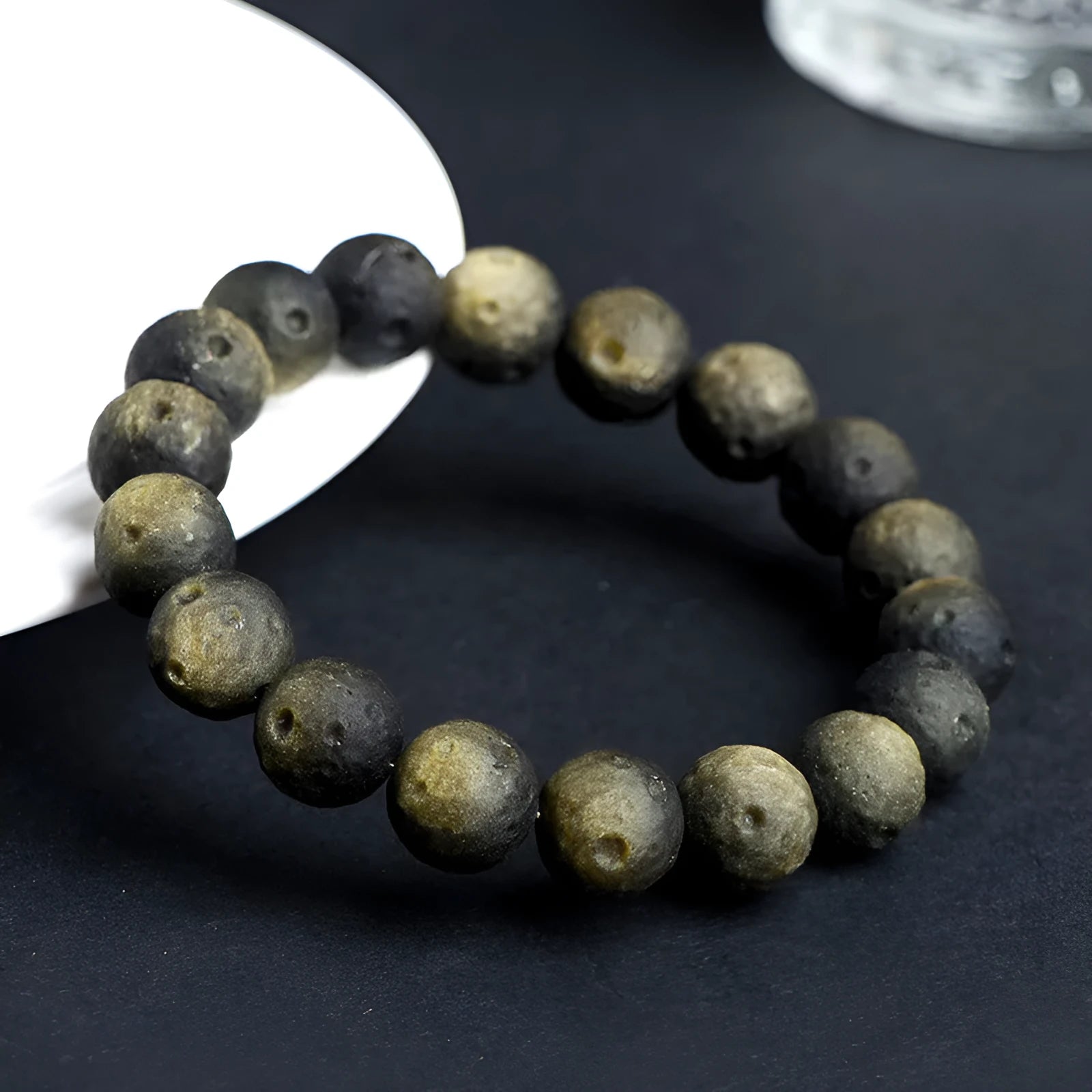 Obsidian crater ball bracelet with textured meteorite-like beads on elasticated cord