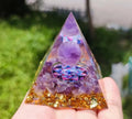 Clear resin pyramid ornament with embedded crystal gravel pieces, 6cm tall with hanging cord.