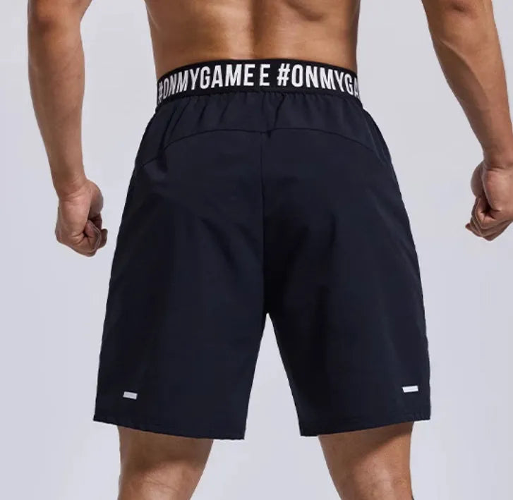 Men's loose black sports shorts with elastic waist and letters detail, laid flat.