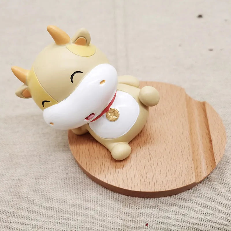 Decorative resin mobile phone stand in a choice of styles including animal figures and wood-effect designs.