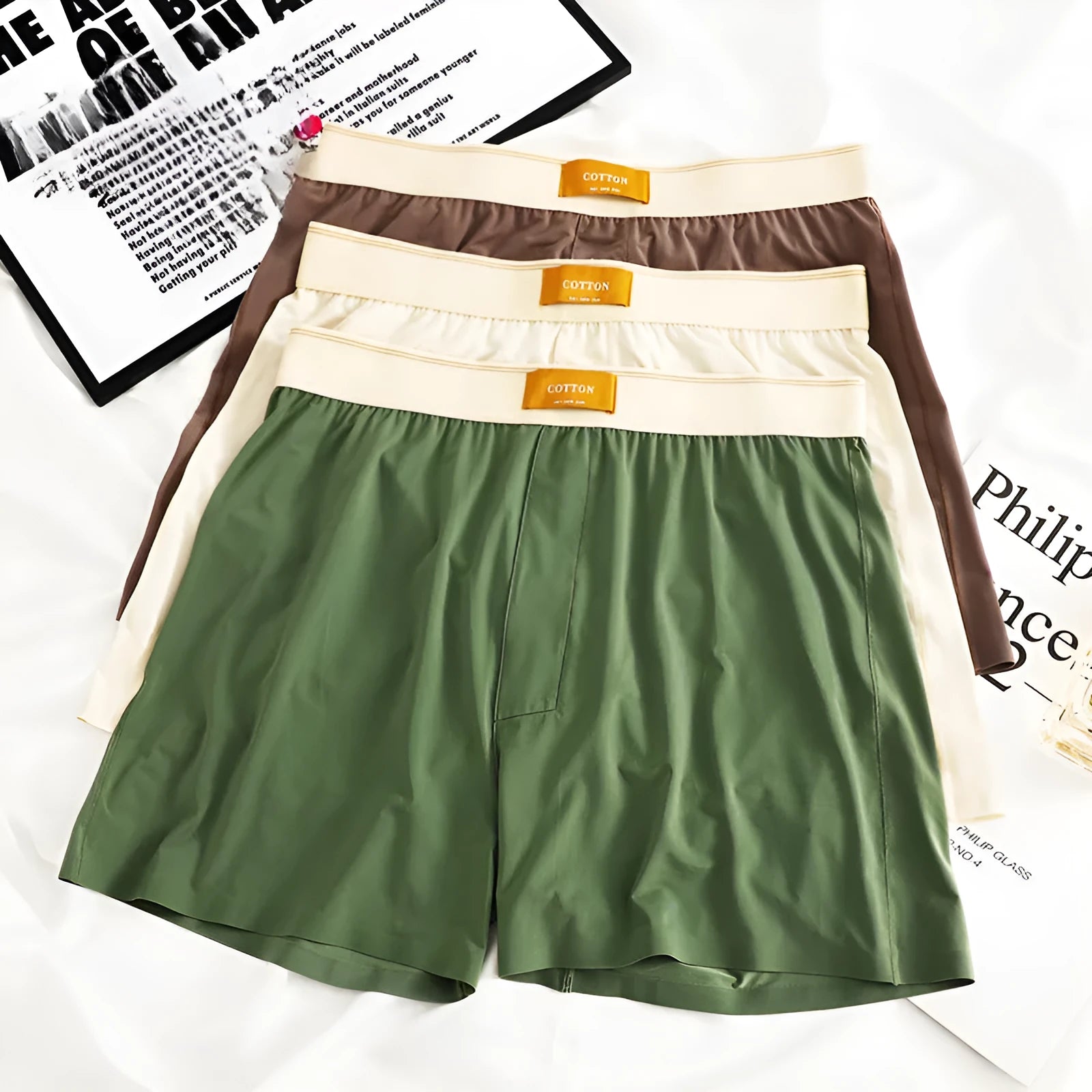Men's solid colour loose ice silk underwear in a pack of three, shown in beige, black, and grey.