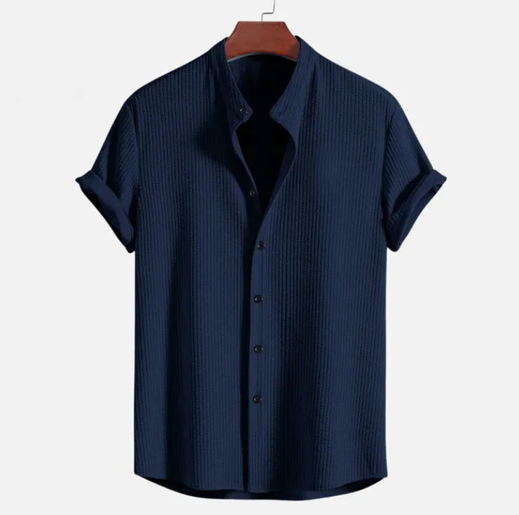 Man wearing a loose-fit short sleeve casual shirt in a solid colour, available in multiple sizes.