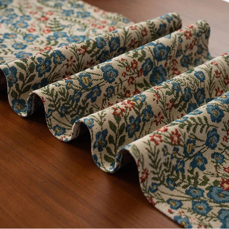 Nordic jacquard table runner with tassel trim in dark blue striped pattern laid on a wooden table.