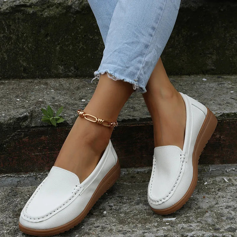Women's flat slip-on loafers in PU leather with car suture detail, shown in multiple colours.