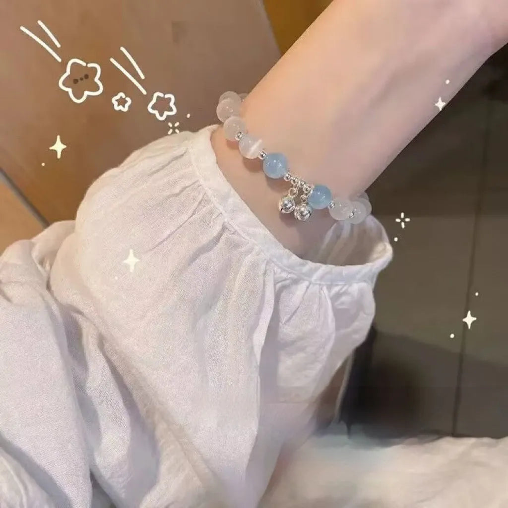 Close-up of a drop-shaped glass butterfly bracelet with round coloured beads on a wrist.