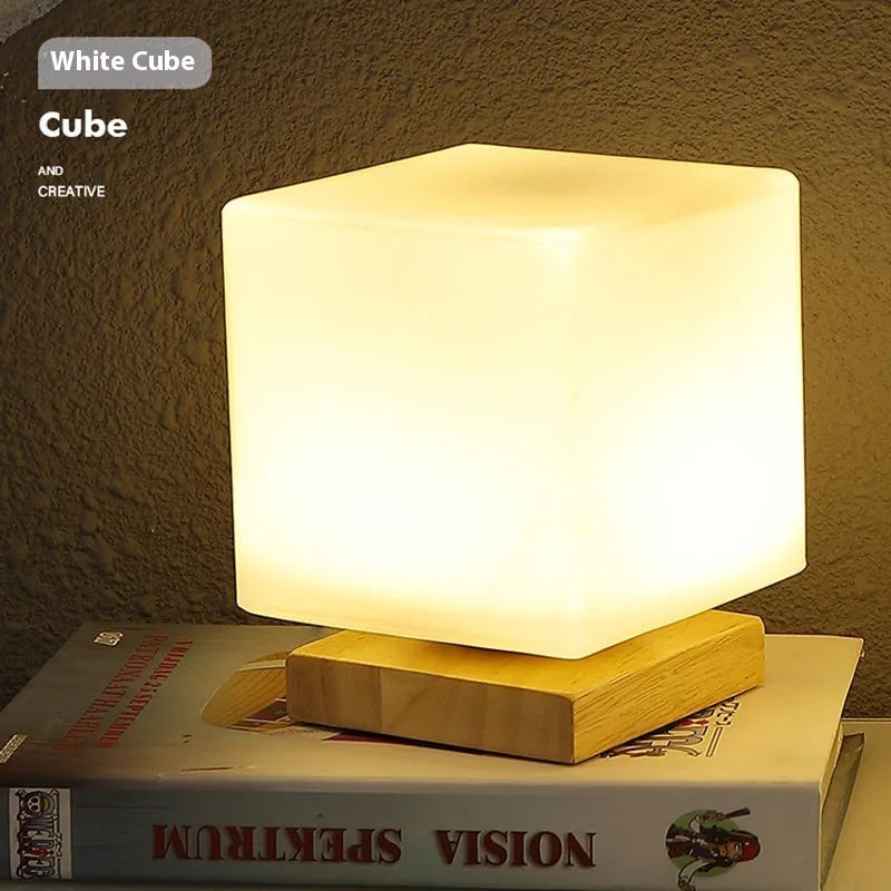 Nordic solid wood base USB table lamp with a white geometric shade on a wooden table.