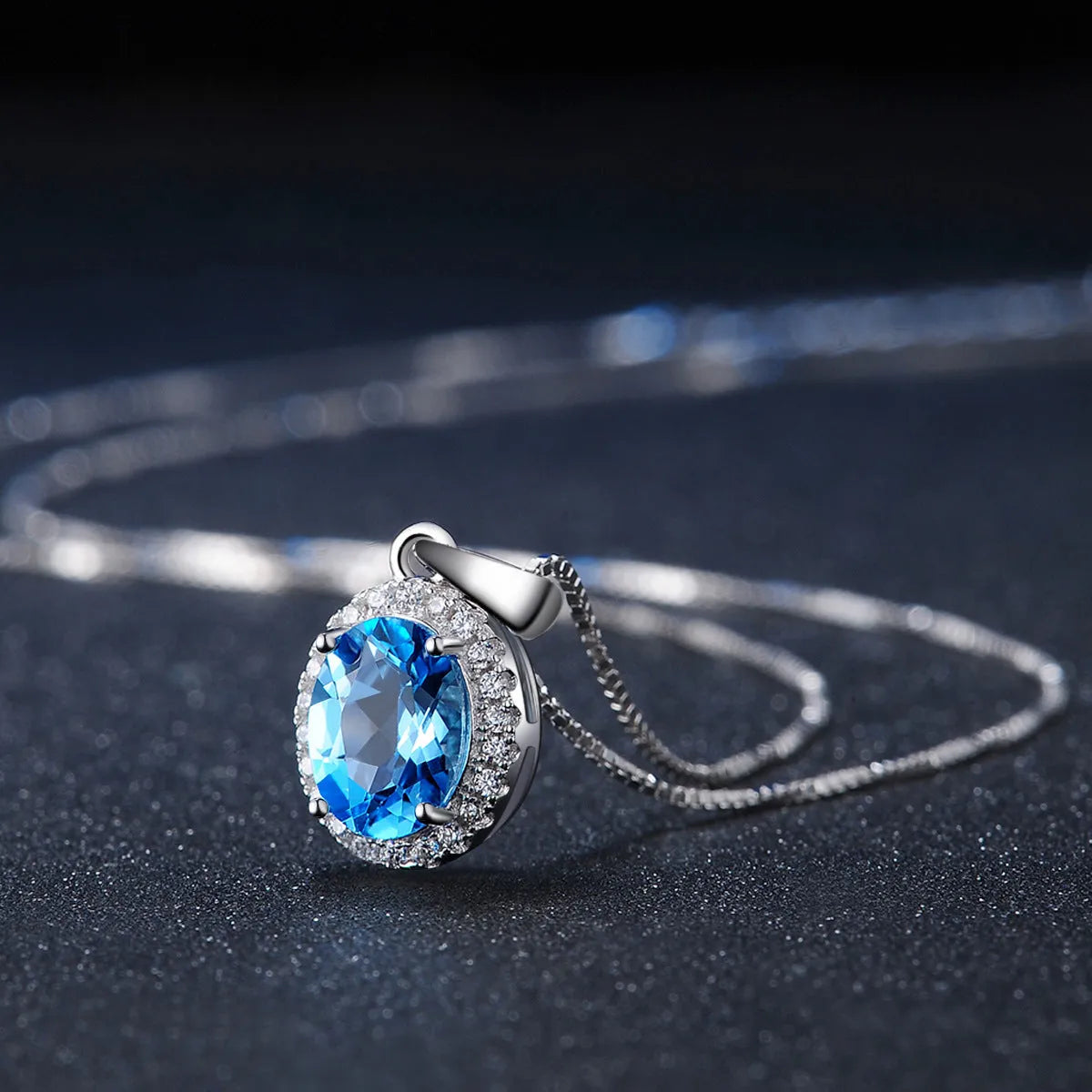Geometric blue topaz and sterling silver four-piece jewellery set with earrings, ring, pendant, and necklace.