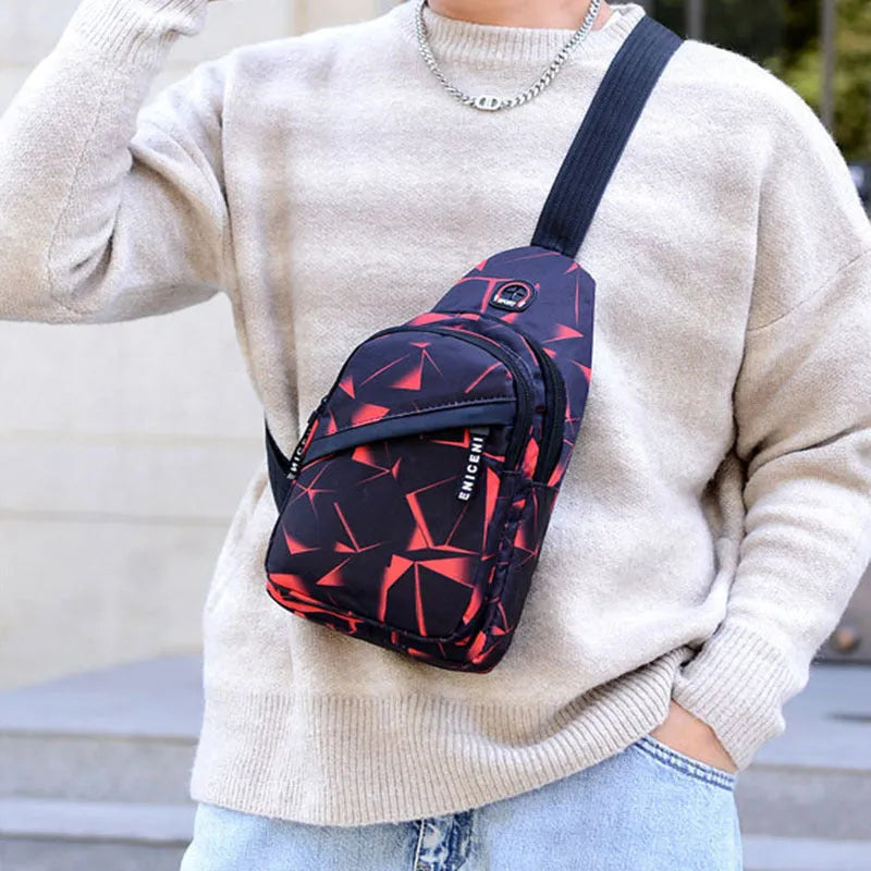 Men's blue Oxford cloth crossbody sling bag showing earphone hole and front zipper.