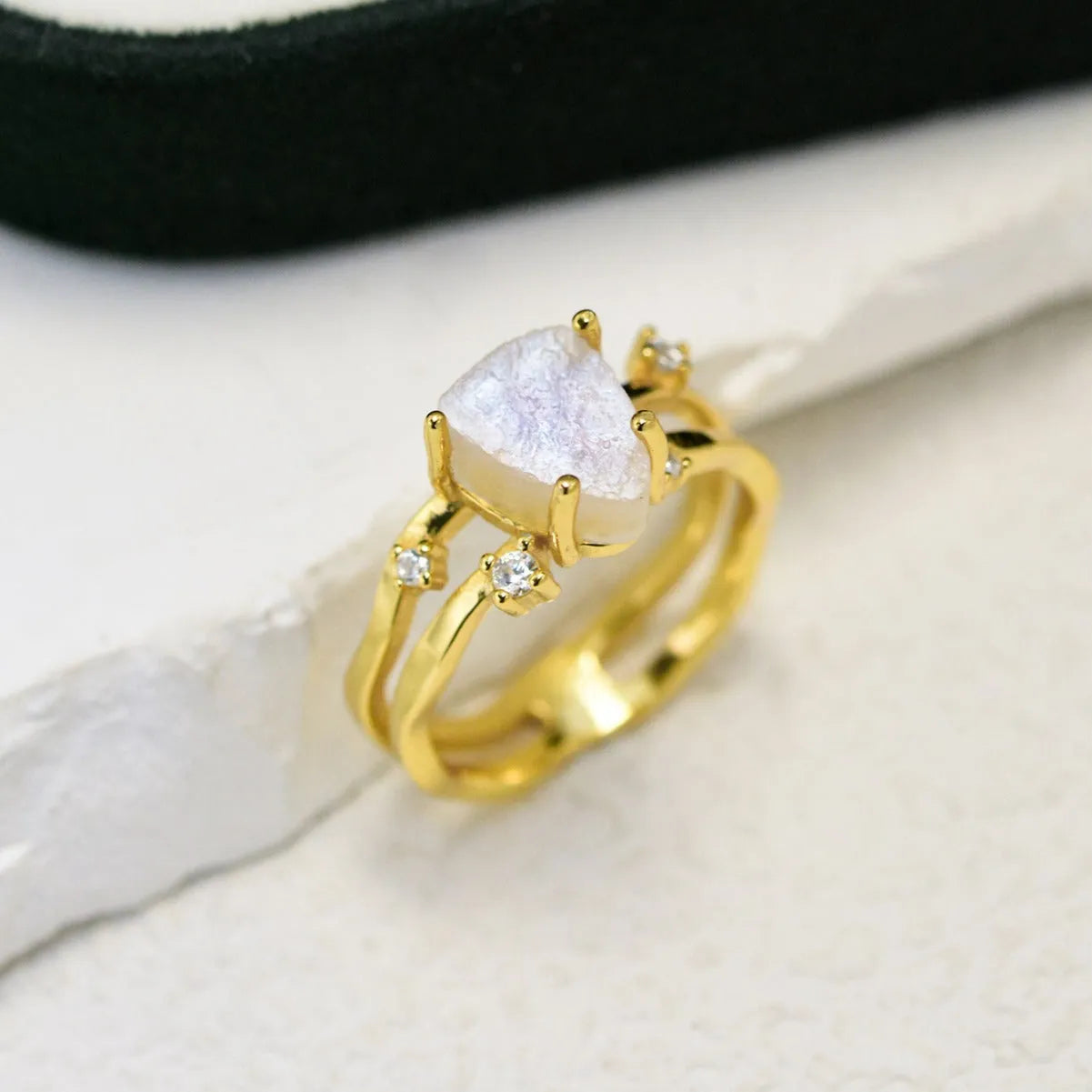 S925 sterling silver ring with irregular triangle shape holding a moonstone, shown in rose gold electroplated finish.