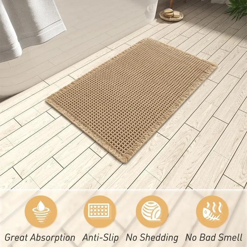A square, checkered-pattern absorbent bathroom floor mat with a non-slip backing, shown in a neutral colour.