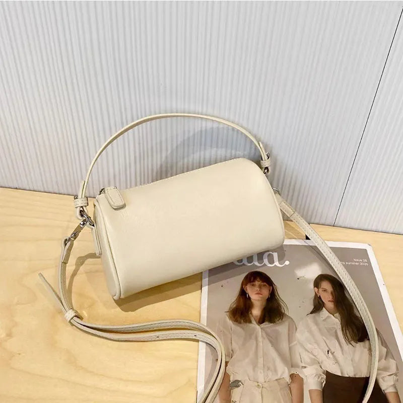 Soft brown genuine leather cylindrical crossbody phone bag with adjustable strap.