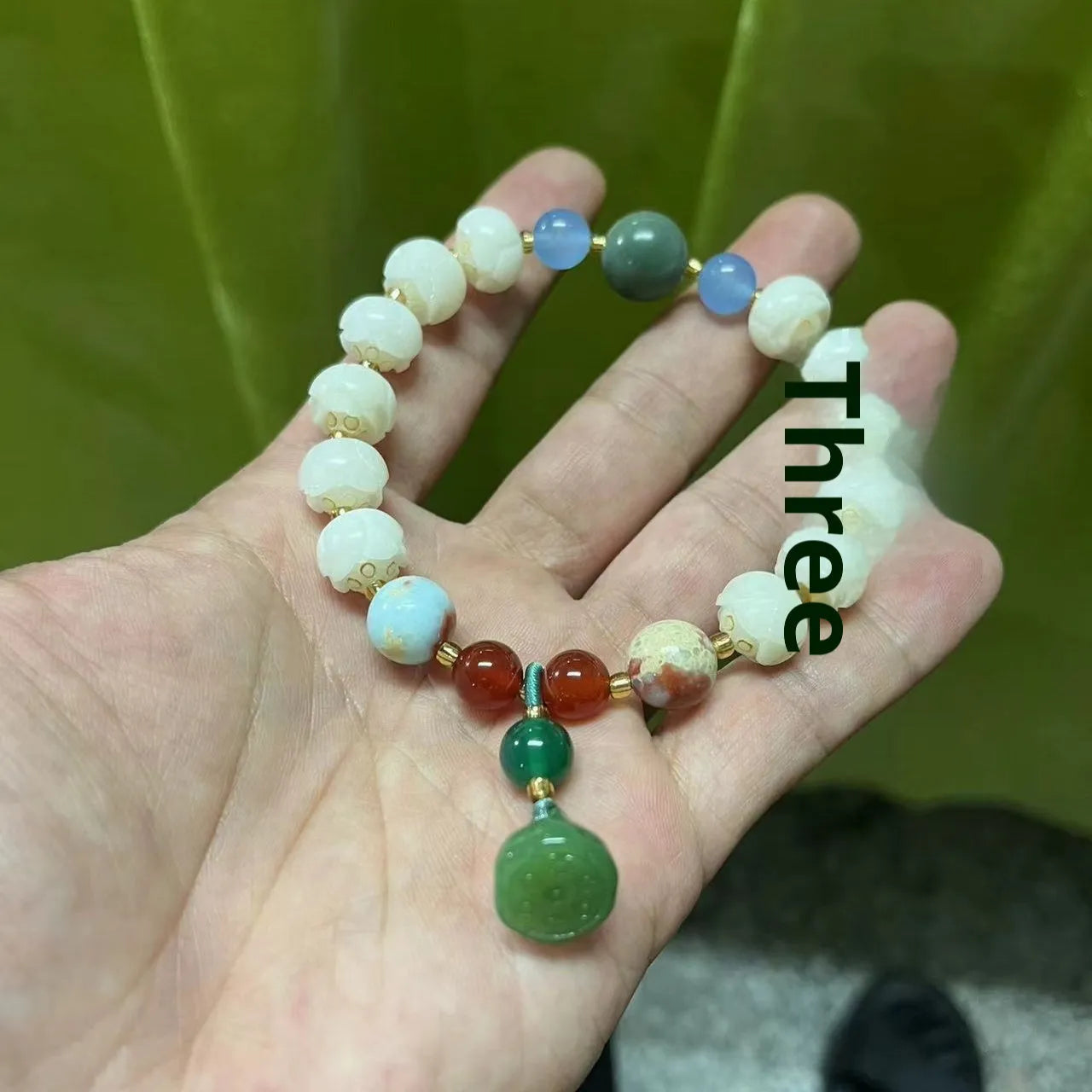 Carved Bodhi root bracelet with white jade, lotus, and pumpkin beads in various sizes.