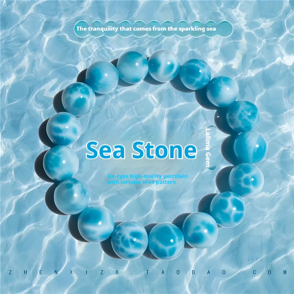 Blue handmade bodhi bracelet with natural sea-pattern crystal beads and pearl details on a wrist.