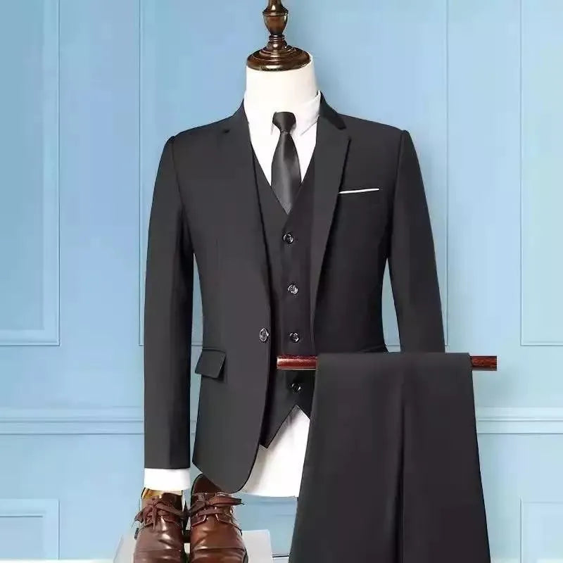 Men's slim fit three-piece suit set in black, including jacket, trousers, and tie on a hanger.