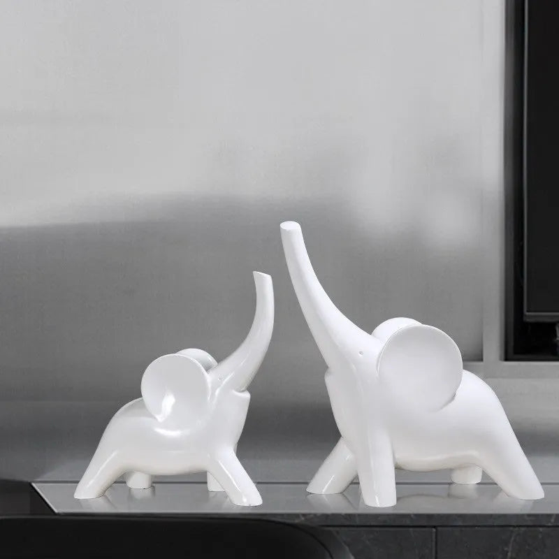 Modern minimalist solid resin elephant ornament in rose gold or white finish on a shelf.