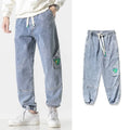 Men's loose-fit tapered cotton trousers in grey on a hanger.
