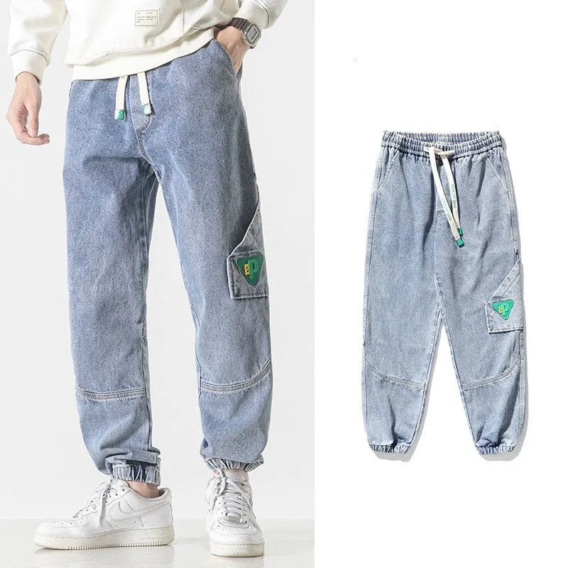 Men's loose-fit tapered cotton trousers in grey on a hanger.