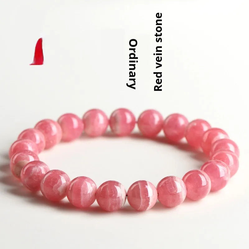 Women's red crystal bracelet with a geometric longevity lock clasp on a wrist.