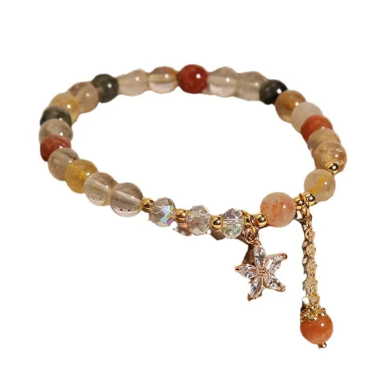 Colourful hair crystal bracelet with cat's paw, flower, butterfly, and coin purse charms on an adjustable band.