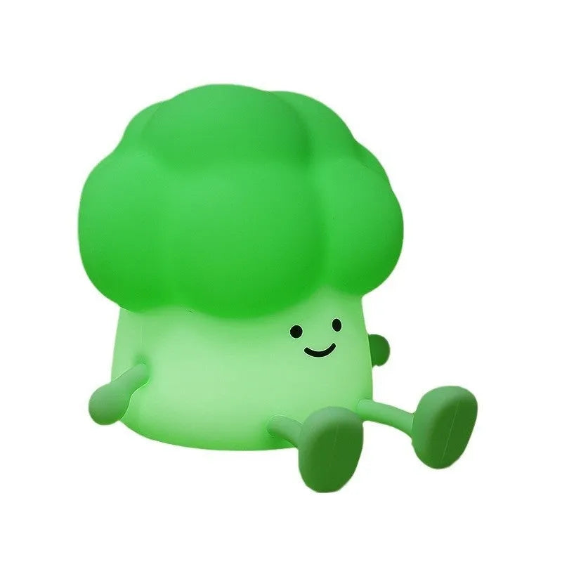 Cartoon eggplant-shaped small night lamp with soft yellow glow, shown next to a broccoli design variant.