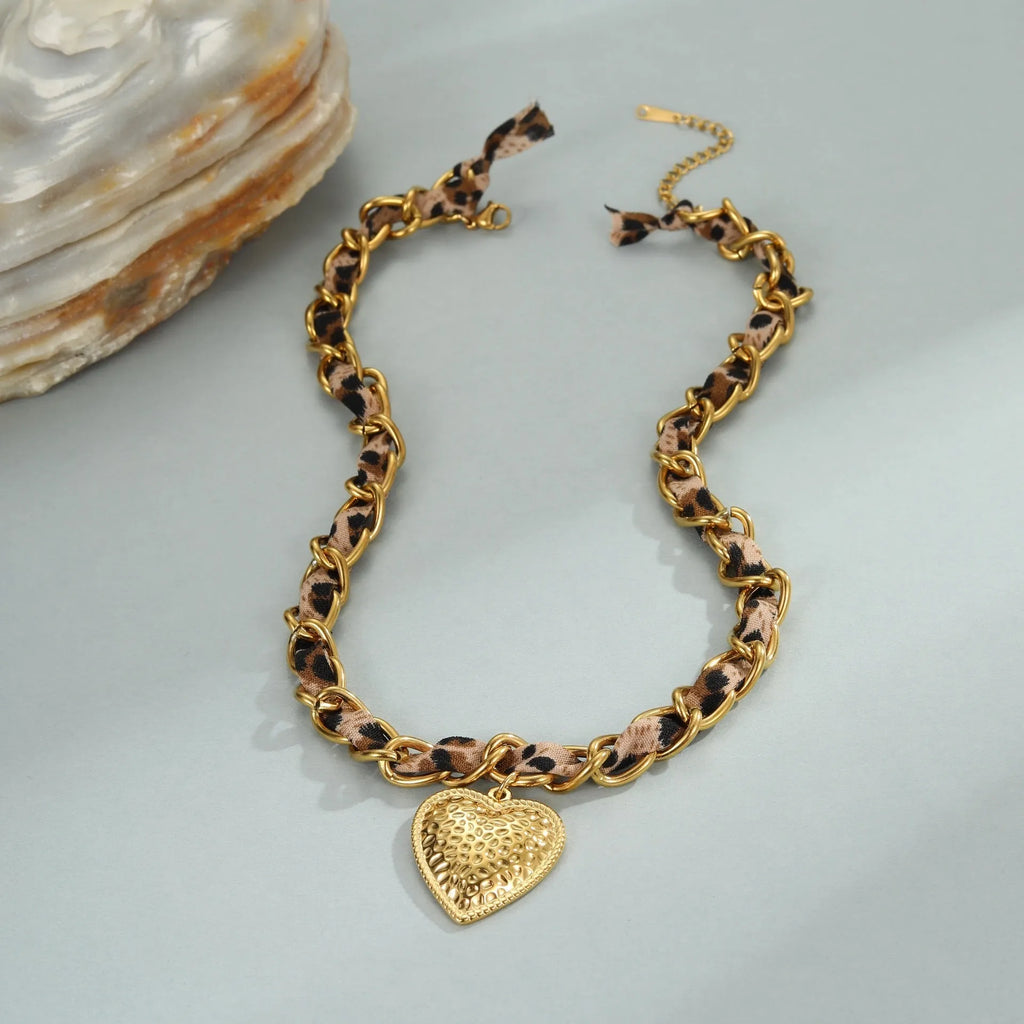 Leopard Love stainless steel necklace with 18K gold plating, showing geometric Big Heart or Love Sun pendant on an adjustable chain.