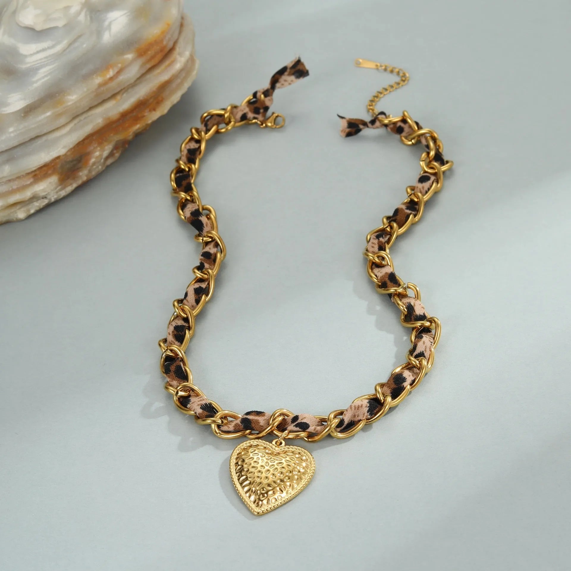 Leopard Love stainless steel necklace with 18K gold plating, showing geometric Big Heart or Love Sun pendant on an adjustable chain.