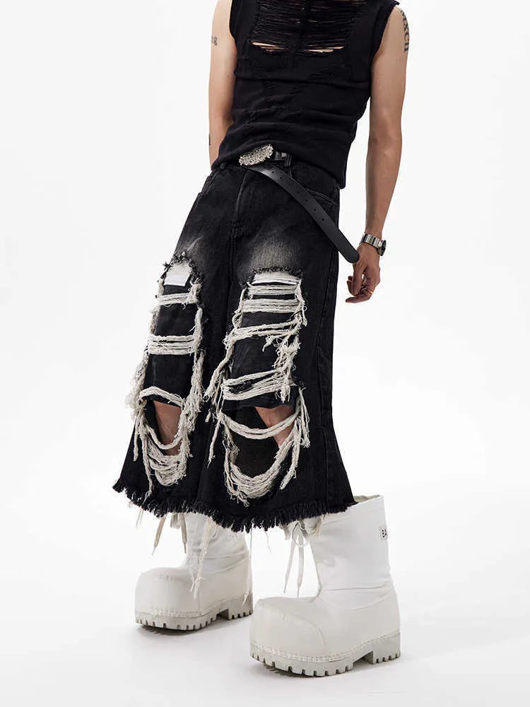 Woman wearing black cropped wide-leg jeans with a mid-high waist and ripped patchwork details