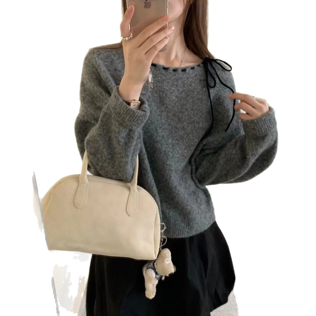 Grey loose-fitting women's long sleeve pullover sweater on a hanger