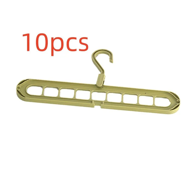 Green plastic folding clothes hanger with nine holes for organising trousers on a rack.