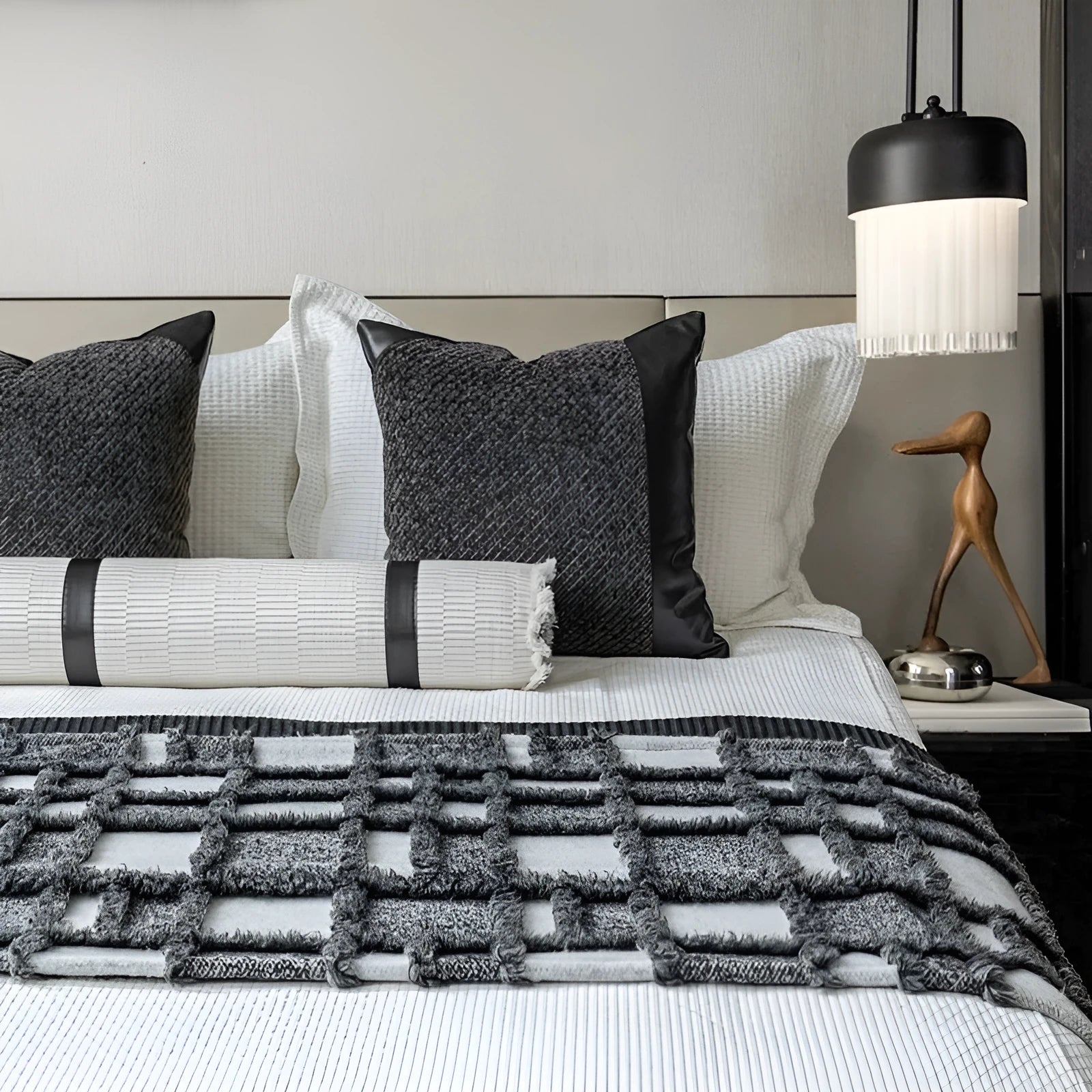Grey and white plaid bed runner blanket and matching pillow on a double bed.