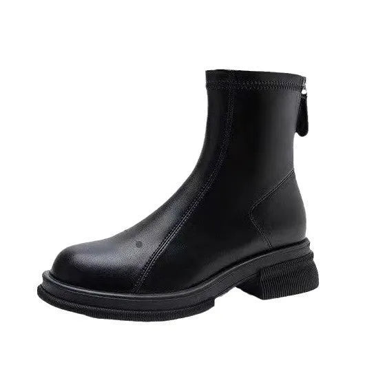 Women's black ankle boot with flat heel and back zipper on a plain background.