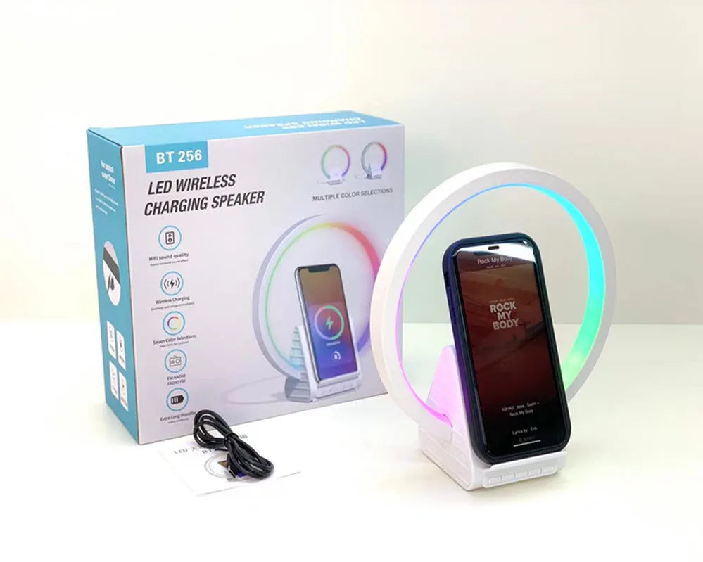 White rectangular smart Bluetooth speaker with integrated wireless charging pad and ambient light on a desk
