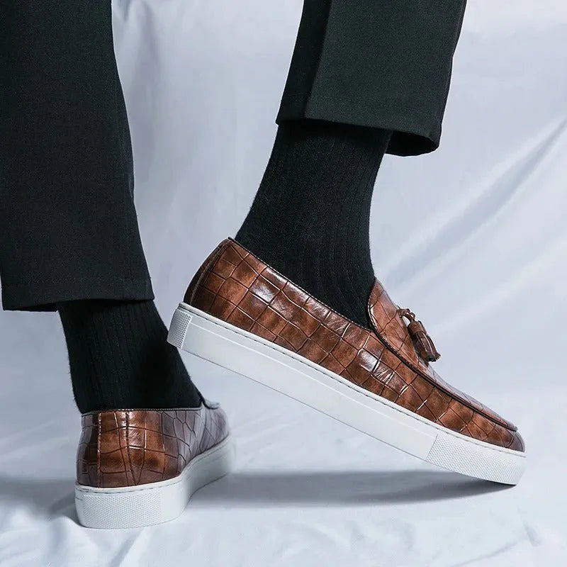Men's brown artificial PU leather slip-on sneakers with a tassel detail on the round toe.