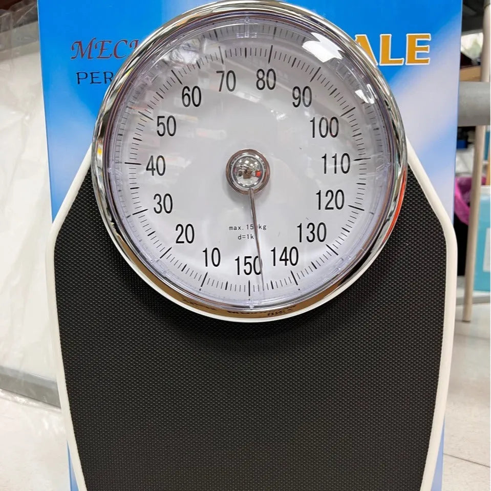 Black mechanical bathroom scale with large analogue dial showing weight measurements