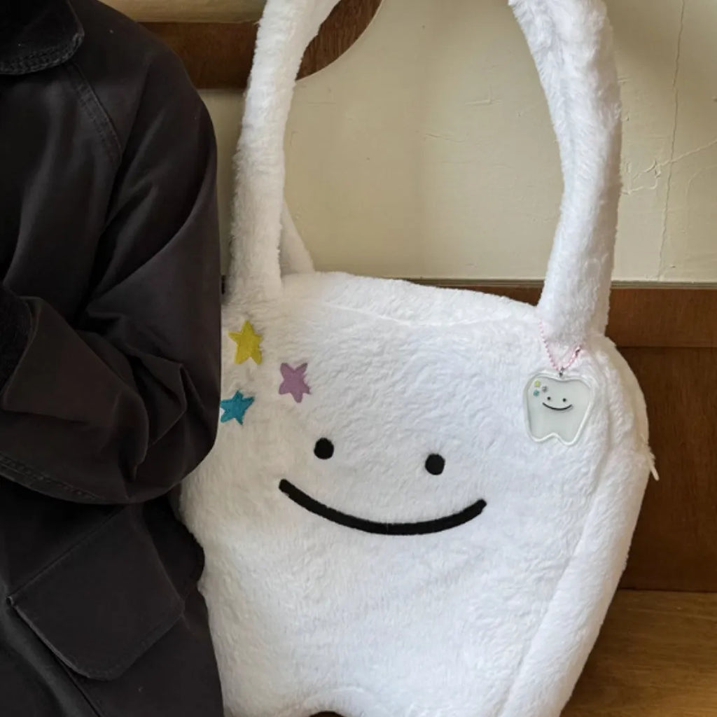 White plush shoulder tote bag with a large capacity and playful cute teeth design, shown with a crossbody strap.