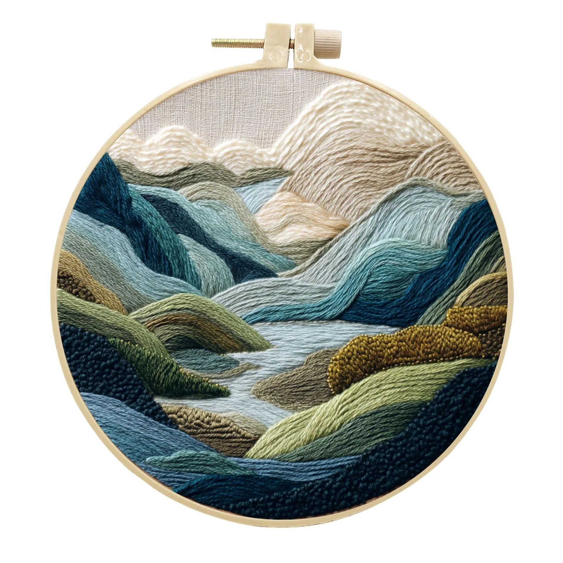 Embroidery DIY kit with bamboo frame, cotton fabric printed with a landscape scene, threads, and needles laid out