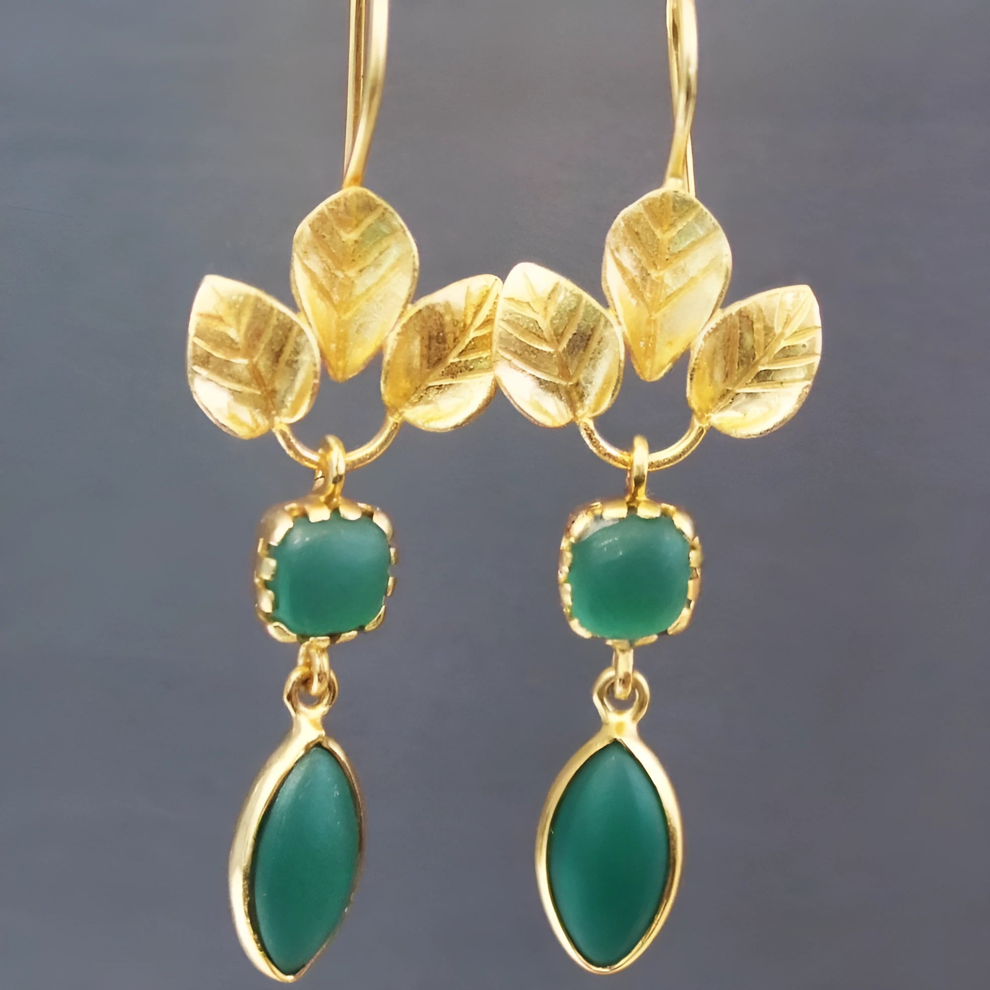 Gold-coloured drop earrings with French leaves design and water drop zircon stones on a copper base.