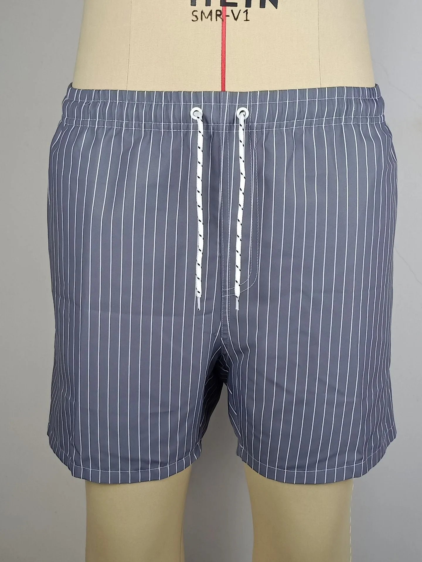Men's striped polyester beach shorts in light blue with straight leg cut