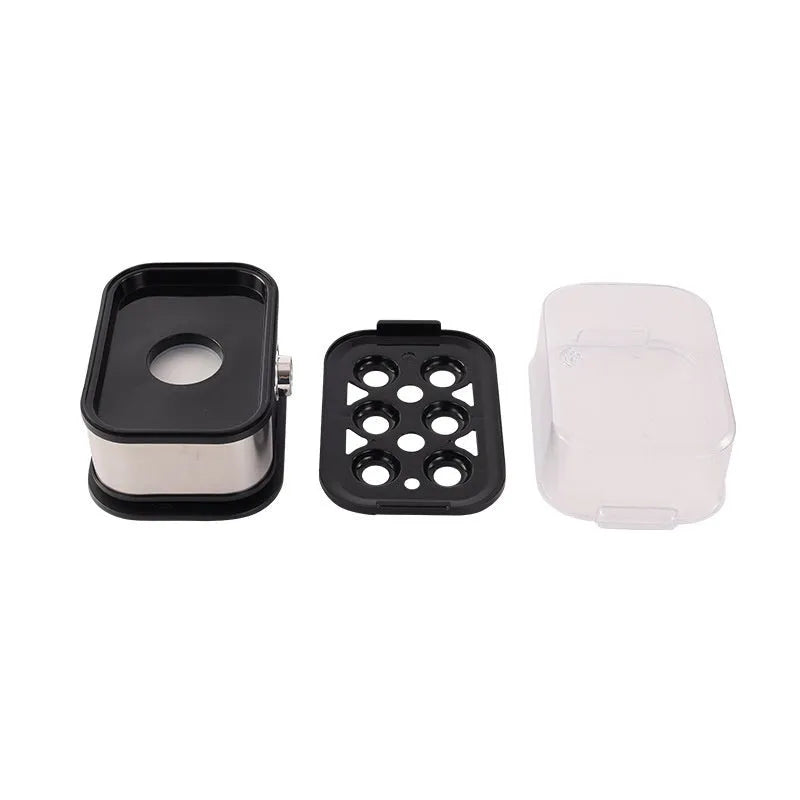 Black portable stainless steel egg boiler with carrying belt on a table.