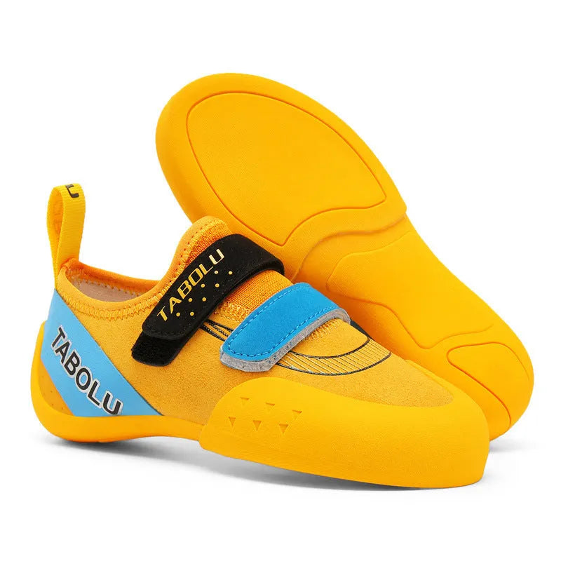 Beginner rock climbing shoes with Velcro straps and a coloured rubber sole on a climbing hold.