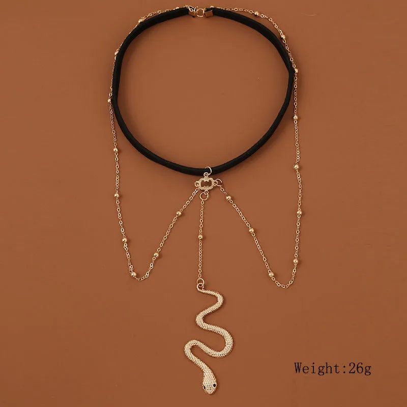 Gold metal beaded thigh chain with large snake pendant and artificial gem inlay, worn on a woman's leg