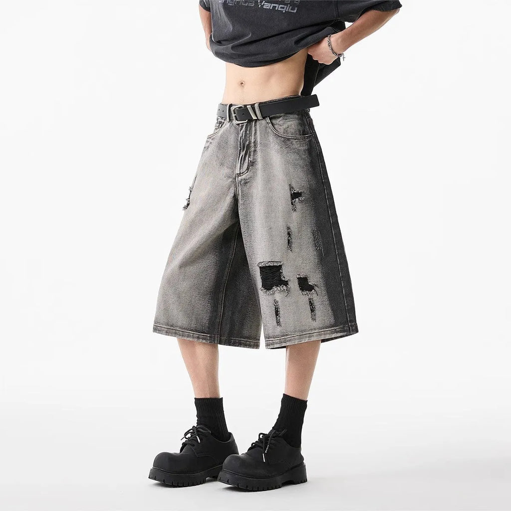 Grey water washed hole denim shorts with loose fit and cropped length on hanger
