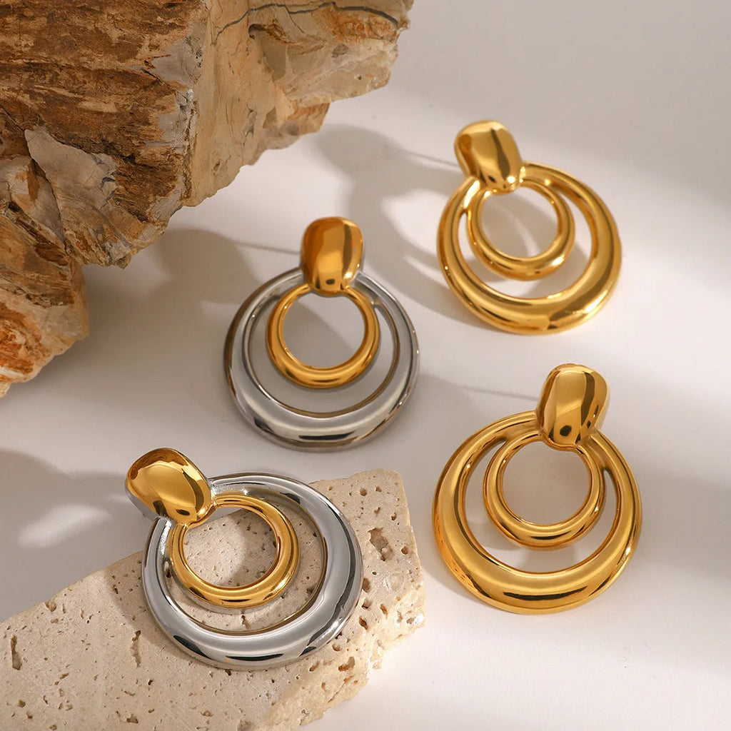 A pair of round gold-coloured geometric stud earrings with a double-layer hollow design.