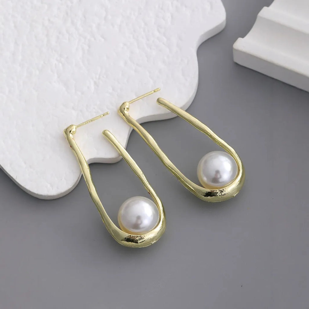 Gold-tone hook earrings with an irregular natural pearl in a vintage European style