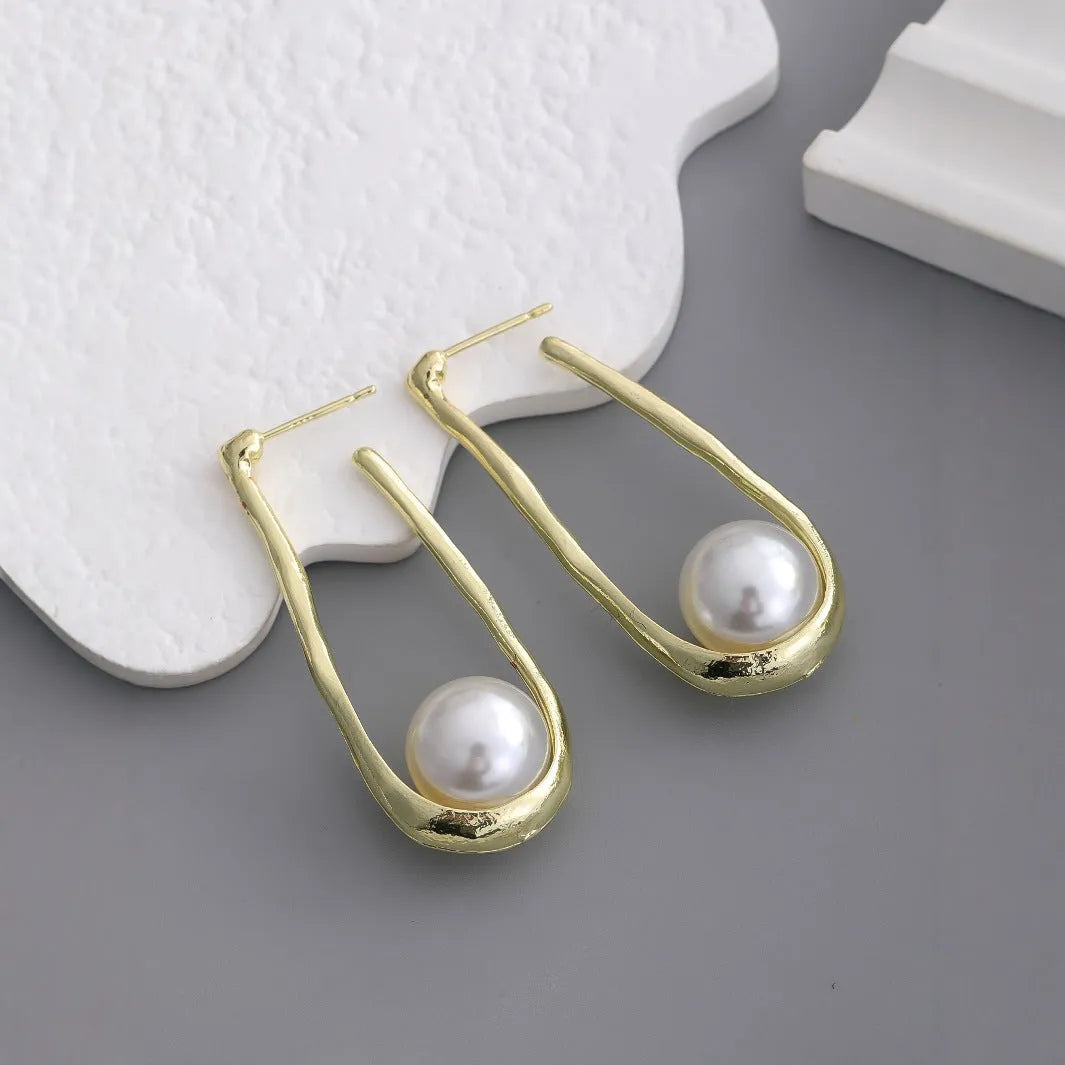 Gold-tone hook earrings with an irregular natural pearl in a vintage European style