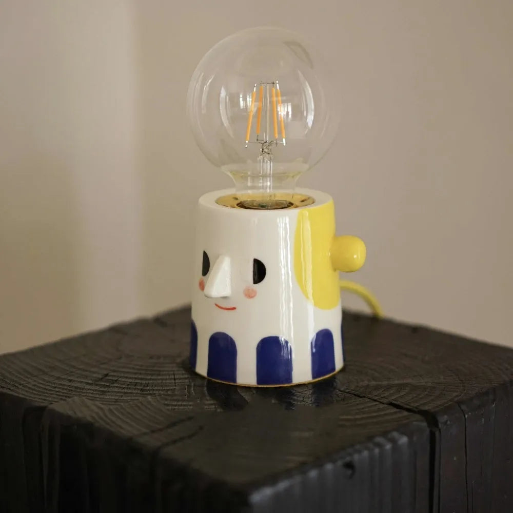 Handmade ceramic table lamp with a spherical ball headlight shade on a ceramic base.