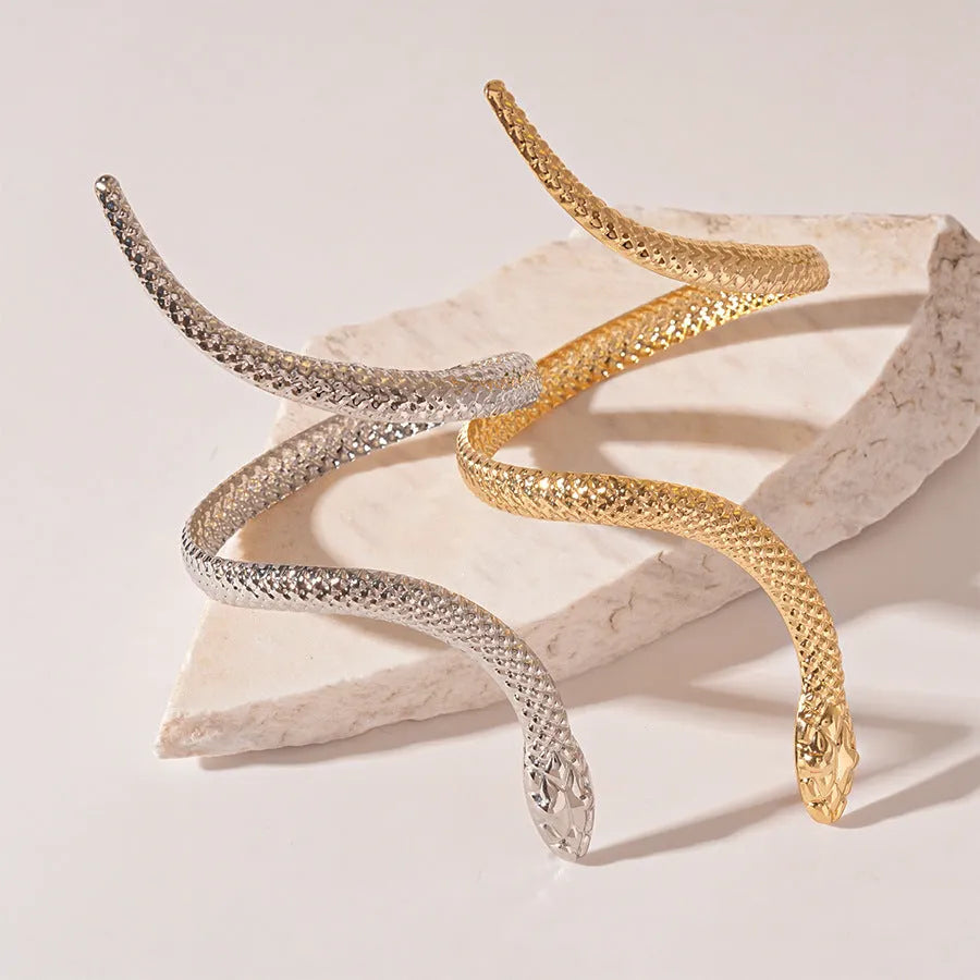 Gold exaggerated twisted snake ring and bracelet jewellery set on display