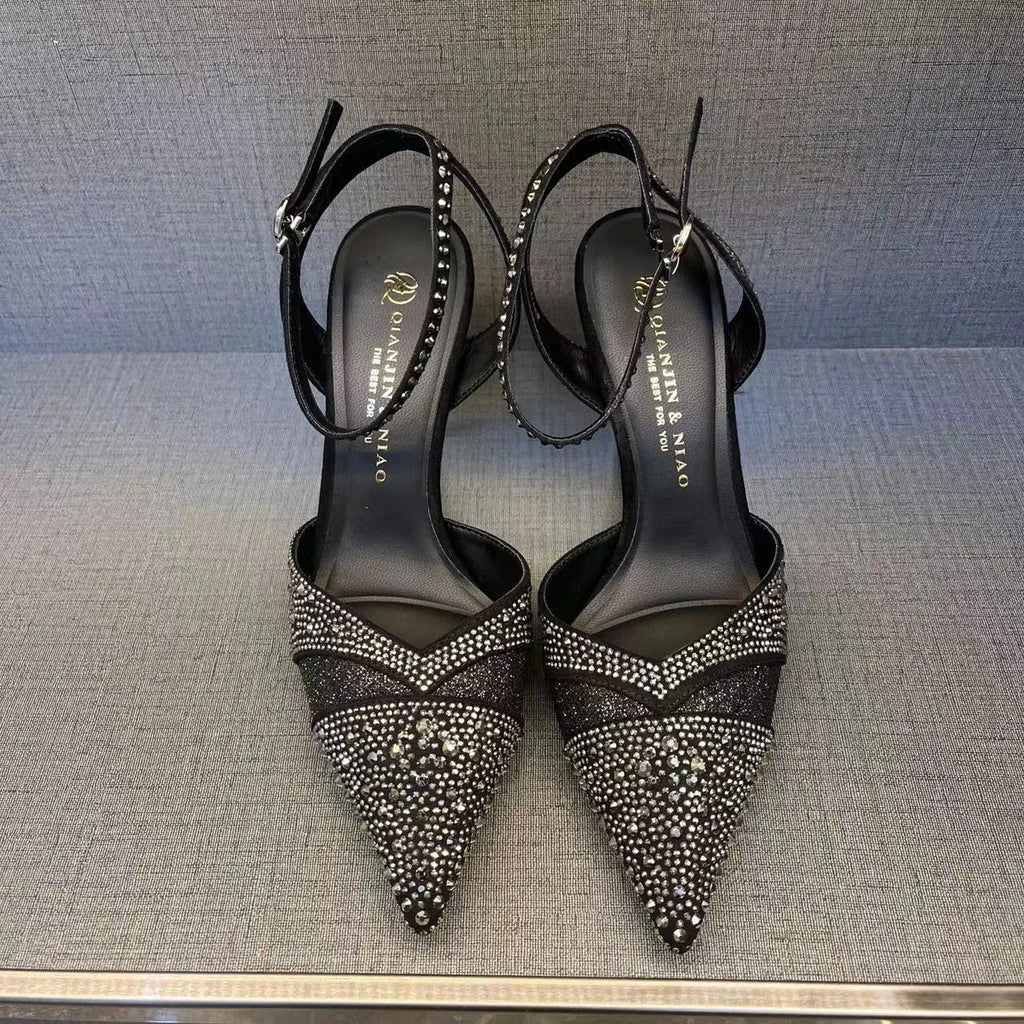 Women's silver high heel shoe with stiletto heel, pointed toe, and red sole on a white background.