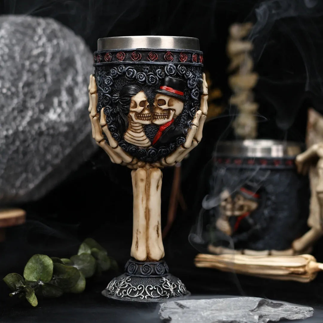 A pair of stainless steel wine glasses with a detailed red human skeleton pattern on a black background.