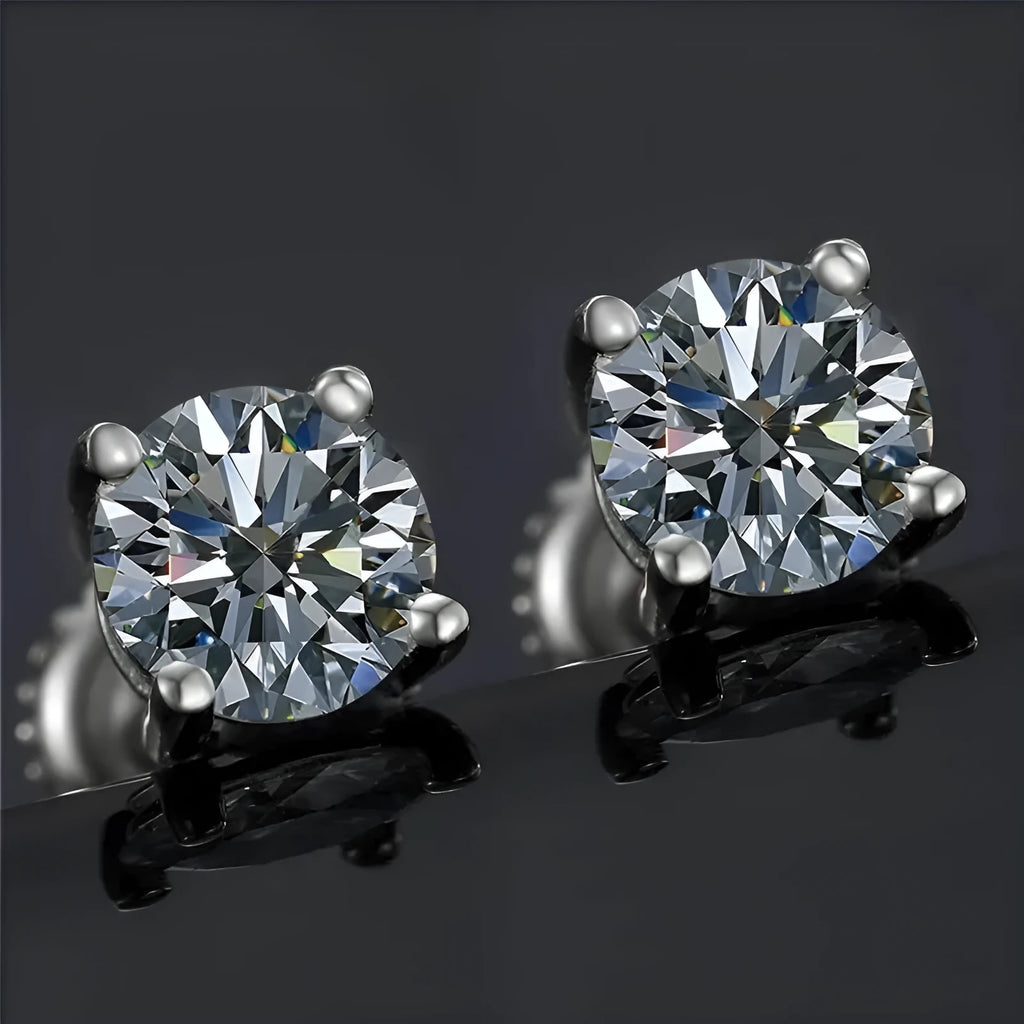 Close-up of silver geometric moissanite stud earrings with screw claw setting on a black card.